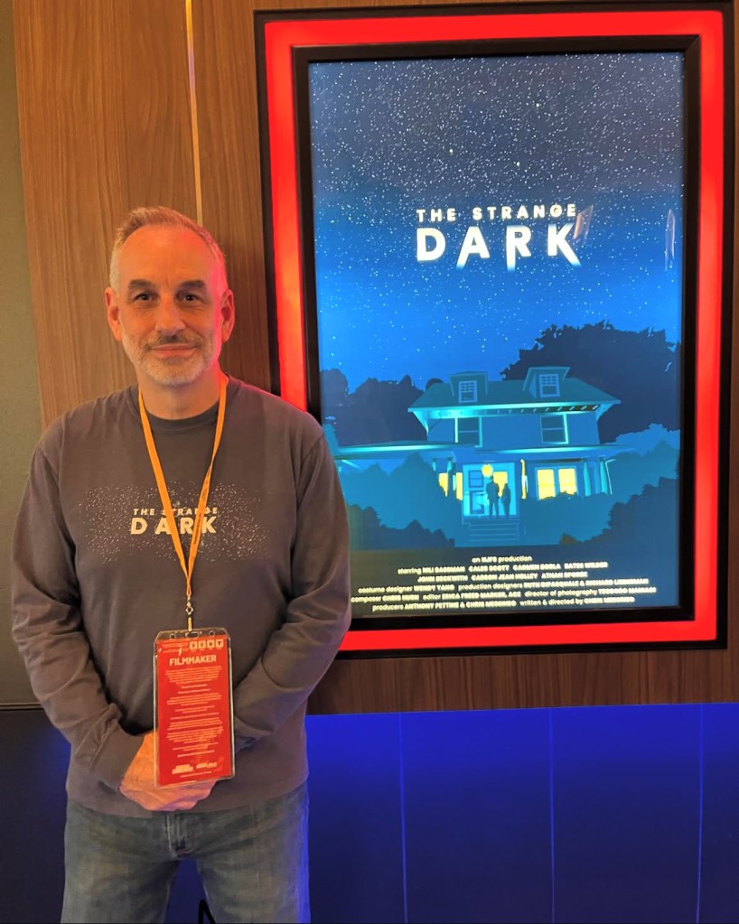 Chris Messiano photographed at the Phoenix Film Festival in front of The Strange Dark movie poster