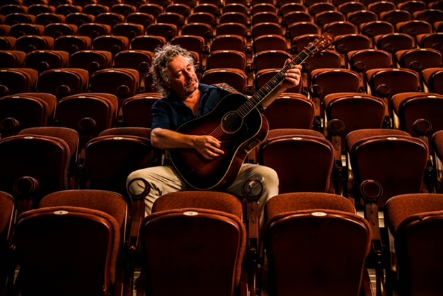 James Maddock with a guitar sitting
