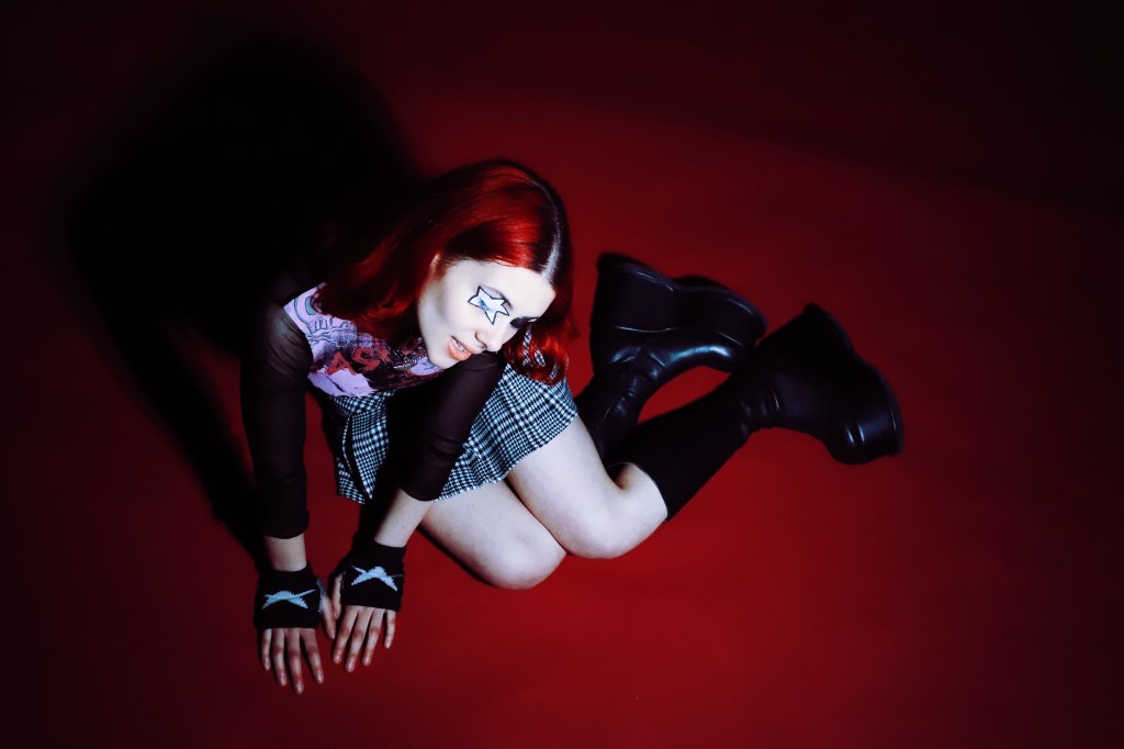 Nectarine Girl posing on a red backdrop