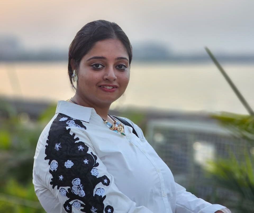 Srijani Mitra posing in front of a waterscape