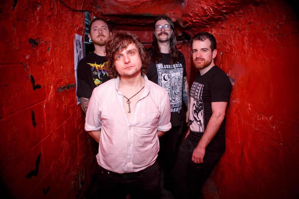 Bobby Mahoney and his band standing in a red hallway