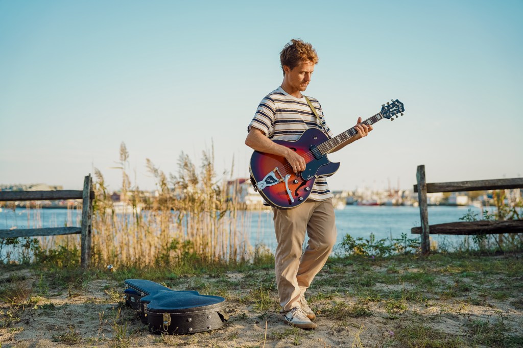 Cole Hallman playing guitar outside